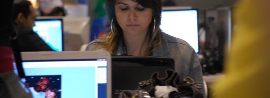 A young woman checking her computer in a public space